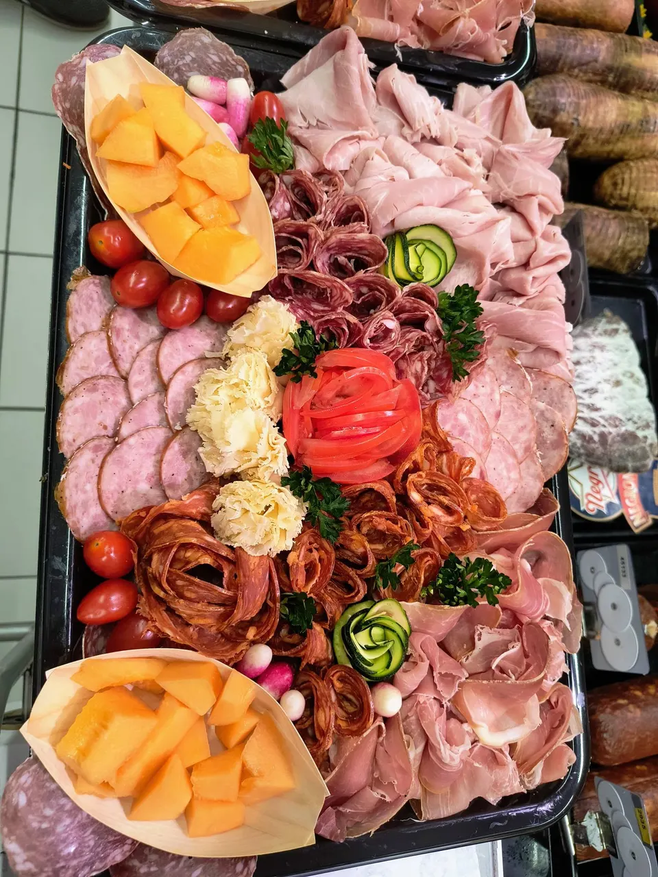 Plateau de charcuteries avec barquettes de melon, rose de tomate et roses de chorizo